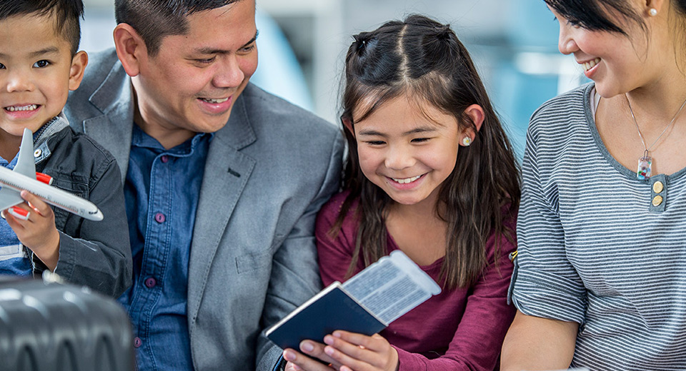 family at the airport holding passports and flight tickets
